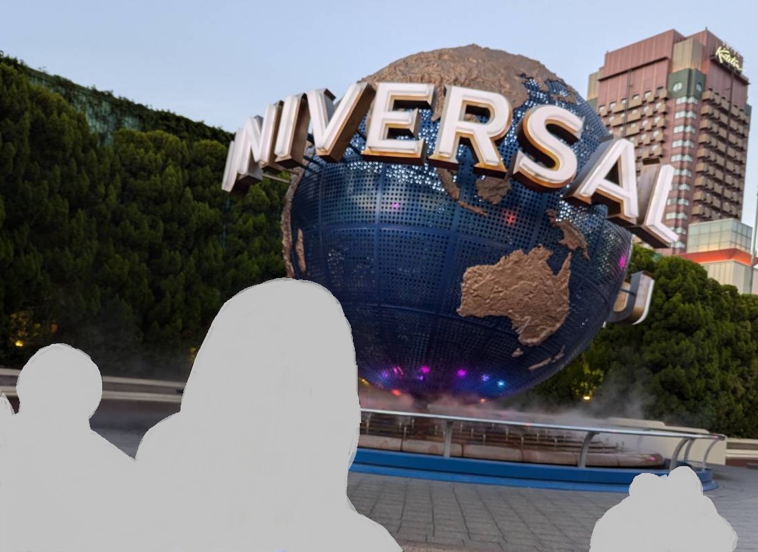 ユニバーサル・スタジオ・ジャパンのエントランスにある地球儀オブジェ「UNIVERSAL」の前で撮影された写真。来場者の姿は完全に塗りつぶされており、パークの象徴的な風景が印象的に写っている。