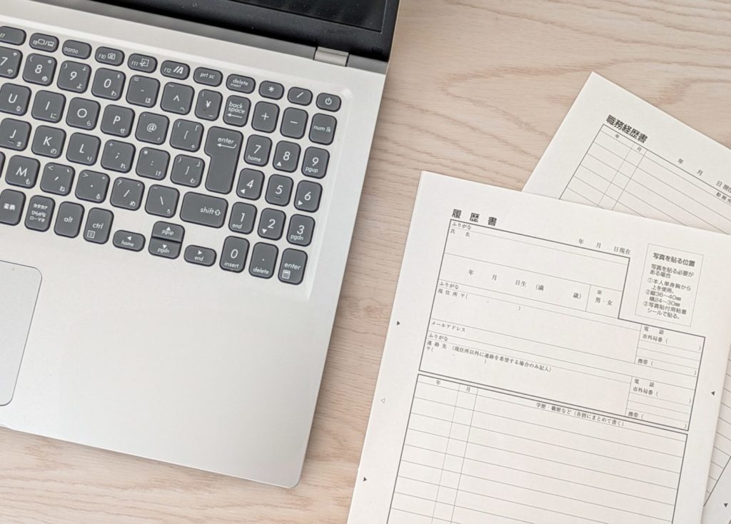 履歴書と開かれたノートパソコン