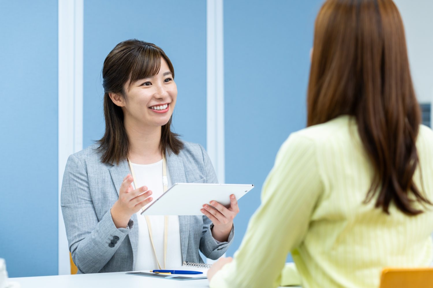 相談する女性と、説明する女性が向かい合わせで座っている画像。就労移行支援の見学のイメージ